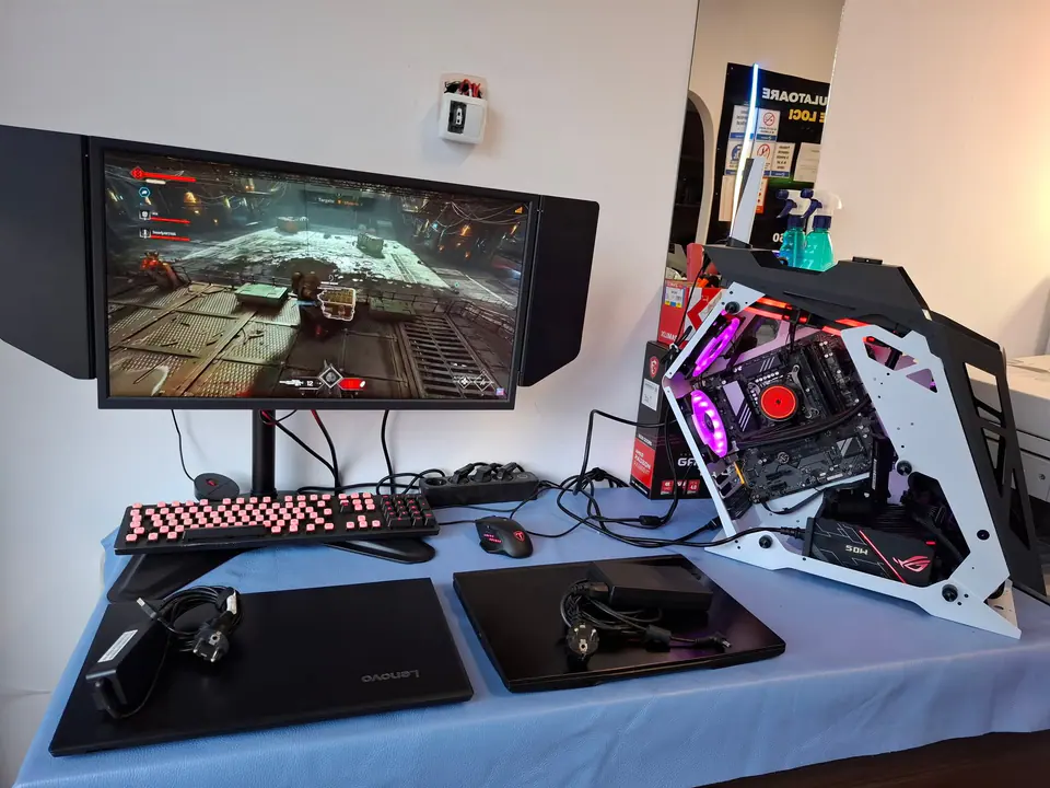 Stație de testare cu monitor, laptopuri și calculator gaming deschis